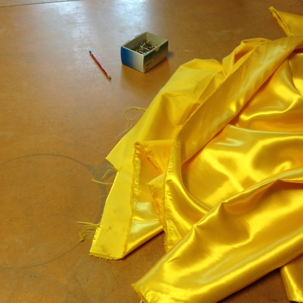 Yellow satin on the cutting table. 